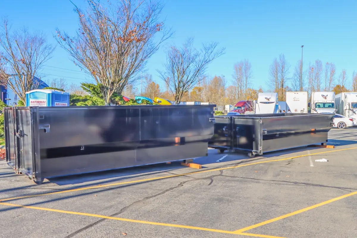 Professional dumpster rental service with roll-off container on residential driveway in Devils Lake